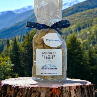 Peppermint Homemade Scottish Tablet sitting on a tree stump with mountain and valley views